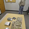 Fayetteville police captain Kenny Yates stands Tuesday near 10 pounds of marijuana and three digital...