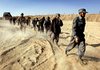 U.S. Marines escort new Afghan policemen to their base in Khan Neshin in the volatile Helmand province, far south of where the offensive against the Taliban was under way. The Afghan officers will train alongside the Marines.