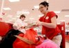 Target associate Jelin Castro packs Wanda Ford’s bags at the checkout counter Thursday in Rogers. Castro was one of many seasonal workers hired by the store to help handle the holiday workload.