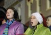 Desiree Long, 12, right, watches the Rogers Christmas Parade on Monday with her cousin Casiday Long, 13. The theme for the parade was “A Dickens Christmas.”
