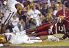 Receiver Joe Adams gets his helmet knocked off by LSU defender Jai Eugene in the fourth quarter of the Arkansas-LSU game at Tiger Stadium in Baton Rouge.