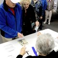 Richard and Jan Abbott present identification to election official Deanna Piatt at Bella Vista Chris...