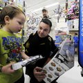 Springdale officer Tommy Wooten, right, helps Ethan Adams, 4, pick out a toy Tuesday at Walmart in S...
