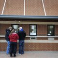 University of Arkansas students stand in the snowfall Wednesday to order tickets to the Liberty Bowl...