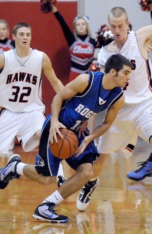 Rogers High guard Wyatt Hively, center, tries to drive around Pea Ridge’s Kip Kelly on Nov. 21. Rogers and Pea Ridge are among the field of teams competing in the Arvest Hoopfest Classic starting today in King Arena at Rogers High.