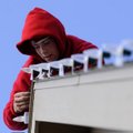 Ricky Brown, installer with Christmas Decor, sets up a string of LED lights Wednesday at Kimberly De...