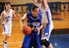 Rogers High’s Grant Holman, center, drives as Woodland’s Tyler McCullough defends during the second half of Thursday’s game at Woodland Junior High in Fayetteville.