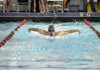 Fayetteville’s Jacob Compton swims the 100-yard butterfly Thursday at the Springdale Har-Ber Invitational in the Jones Center in Springdale.