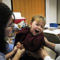 Sara Borchert, 3, cries as she receives both the H1N1 and seasonal flu shots Thursday at St. Raphael...