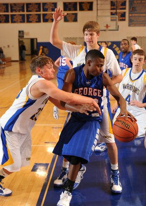 Springdale George’s Dorantez Evans, center, is guarded by Springdale Central’s Junior High’s Tucker Lee, from left, Alex Rice and Hayden Redmond during the first half of Friday’s game in the Coca-Cola Classic in Springdale.