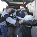 Volunteers load a vehicle with presents Friday during the Sharing and Caring of Benton County distri...
