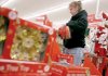 April Denard arranges Christmas supplies last week at the Family Dollar Store on Elm Springs Road in Springdale.