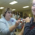 Tabitha Gibbs, a nurse with the Benton County Health Department, gives Audrey Childress of Rogers an...