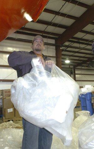 Superintendent Jerrold Haley recycles packing foam at the Rogers Recycling Center. A machine crushes the foam and turns it into blocks.