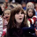 Elm Tree Elementary pupil Emily Vukin (center), 6, reacts as the Bella Vista Women’s Chorus sings a ...