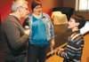 Mitchell Gold, philanthropist and co-founder of Faith in America, left, speaks with Will Phillips, right, and his mother, Laura Phillips, of West Fork before Gold spoke Saturday at the Fayetteville Public Library.