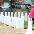 Jenna Evers, 10, of Bentonville, salutes after laying a wreath Saturday at Fayetteville National Cem...