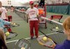 Bradwin Williams, an Arkansas tennis player, works with children Dec. 6 during Kid’s Tennis Day at the University of Arkansas’ Dill Indoor Tennis Complex in Fayetteville.
