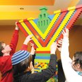 Avi Greene, 16, Jonah Greene, 11, and Deborah Greene, 14, lift the top piece of a 7-foot-tall Menora...