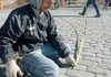 Frank Gonsalves with Ozark Patterned Concrete takes measurements Friday at the intersection of Second and Cherry streets during construction.