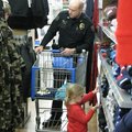 Prairie Grove Sgt. David Collins shops with a young girl Saturday during the first Prairie Grove Pol...