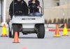 Rogers High School student Heather Gatton, 16, drives a golf cart Monday wearing “drunk goggles” with Student Resource Officer Keith Foster at Rogers High School. The goggles simulate a blood alcohol level of 0.08 to 0.15, Foster said. The exercise was sponsored by the DECA Chapter at Rogers High to remind students the effects alcohol has to impair driving and to make wise choices during holiday vacation, said teacher Tom Woodruff.