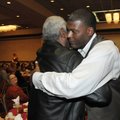 Former NBA basketball player Larry Johnson hugs former University of Arkansas basketball coach Nolan...