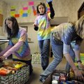 Tiana Leiva, 12, left, Hannah Foster, 12, and Tatum Waltrip, 10, pack food baskets to benefit four n...