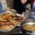 Finished latkes are put on a tray and kept warm in an oven before being served at the Etz Chaim syna...