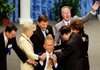 TV evangelists (from left) Gloria Copeland, Kenneth Copeland, Charles Green, Richard Roberts, and Lindsay Roberts lay hands on Oral Roberts in June 2003. 