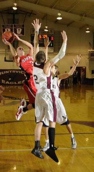 Farmington’s Evan Yochum takes a jump shot over a pair of Huntsville defenders Tuesday.