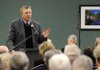 Jerry Mitchell, executive director for the Area Agency on Aging, talks to a crowd Wednesday after the Adult Wellness Center in Rogers received a check for more than $18,000. The Arkansas Senate and House gave the money from the General Assembly’s general improvement fund.