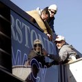 Arkansas Sign and Banner employees (from left) Mike Fink, Tyler Boothe and Brett Williams slide an a...