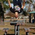 Jordan Hawkins, 17, of Rogers does a back flip Thursday after vaulting over a picnic table at Murphy...