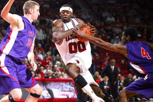 Arkansas' Mike Washington drives between Stephen F. Austin's Will Reinke (34) and Walt Harris (4) Saturday at Bud Walton Arena in Fayetteville. Washington finished with a game-high 25 points in Arkansas' 72-69 win.