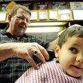 Carson Jackson, 4, gets his hair cut Saturday by Vic Bradford at Townzen’s Barbershop in downtown Ro...