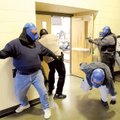 A “hostage” flees a room while law enforcement officers prepare to enter in a live shoot-out exercis...