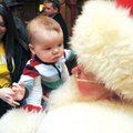 Ashley Ardemagni, from left, hands her son, Chanlyr, 7 months, to Santa on Sunday during an open hou...