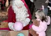 John Patrick, who has played Santa outside his Pocahontas home for 28 years, gives toys Sunday night to Lindsey Gazaway, 6.