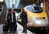 A Eurostar employee (right) assists a passenger at Gare du Nord train station in Paris, France, on Monday.