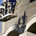 Yuvany Villarreal (left) and Humberto Movera pressure wash the walls of the Legacy Building in Fayet...