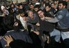 Opposition supporters and pro-government demonstrators scuffle at the funeral ceremony for Grand Ayatollah Hossein Ali Montazeri on Monday in Qom, Iran.