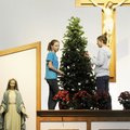 Leah McGinnis, left, and Drew Swalley, both 14, decorate a Christmas tree on the altar Monday at St....