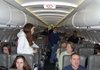 Stranded passengers aboard a JetBlue Airways flight to Cancun walk around the cabin while waiting hours to take off at New York’s Kennedy International Airport on Feb. 14, 2007.