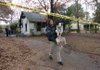 Lindsey Droste, an officer with Conway Animal Welfare, carries a dog that belonged to a mother and three young children who died in a house fire Monday night in Conway. The dog was the only survivor of the blaze. 