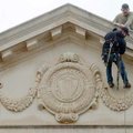 Wes Mabry (on roof) of Northwest Arkansas Sign Shop in Fayetteville helps co-worker Mike Lewis get r...