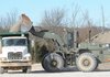 Washington County workers load gravel on Dec. 17 into a dump truck at the county’s Maintenance and Operations Center in Fayetteville.
