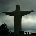 Visitors walk past the Christ of the Ozarks statue as rain clouds roll by Wednesday afternoon at the...