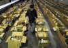 Chuck Davis works to stock boxes of food with bags of chicken early Thursday before opening the doors of the National Guard Armory for Bentonville Kiwanis’ annual food giveaway. The Kiwanians gave away 600 boxes of food to low-income residents.