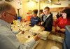 The Church at Arkansas members, from left, Jim Mitchell, Mary Frances Proctor, Kellen Summers and Debbie Beasley work to assemble and distribute meals Thursday at Seven Hills Homeless Center’s Day Shelter in Fayetteville.
